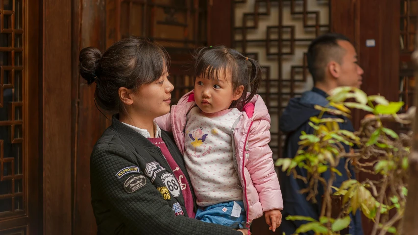 a woman holding a little girl in her arms, inspired by Zhang Zeduan, pexels contest winner, standing outside a house, staff, young commoner, looking this way