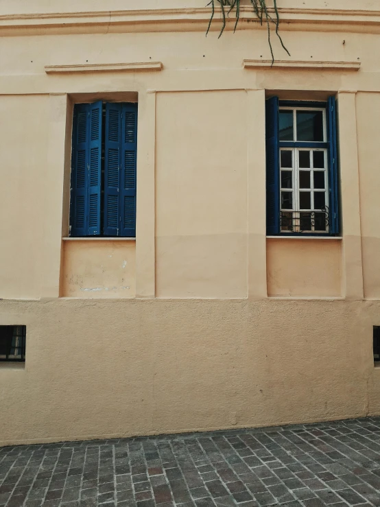 a clock that is on the side of a building, a picture, by Pablo Rey, pexels contest winner, de stijl, blue shutters on windows, ocher details, low quality photo, hyperrealism photo