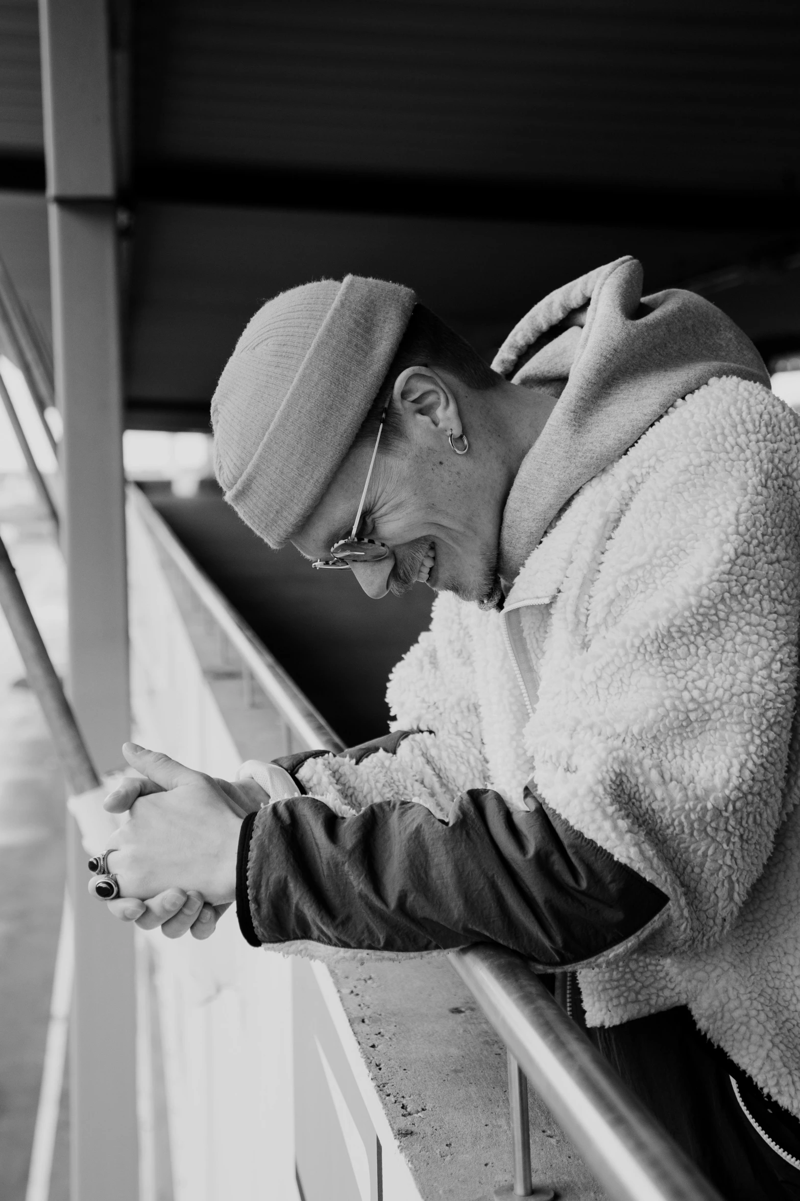 a black and white photo of a man looking at his cell phone, visual art, bad bunny, on ship, wearing a track suit, holding a paintbrush in his hand