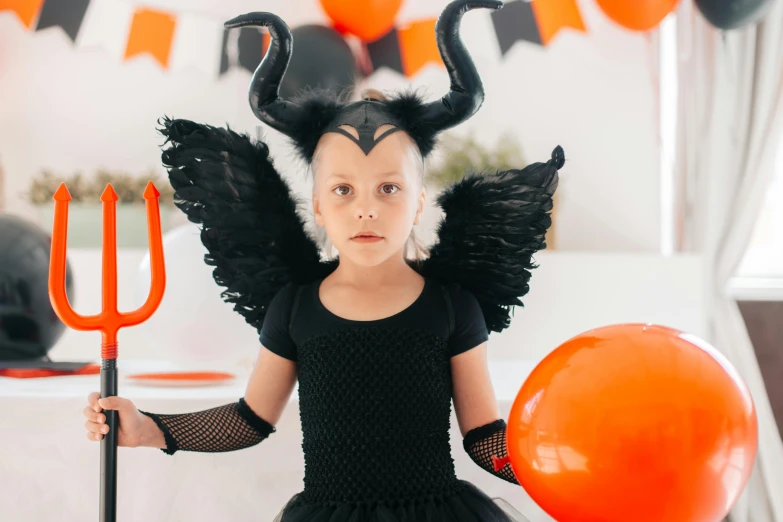 a little girl dressed up as a devil holding a pitchfork, pexels contest winner, black wings, greta thunberg, black swan, holding a balloon