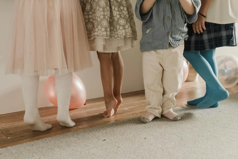 a group of children standing next to each other, pexels contest winner, incoherents, elegant legs, carpeted floor, party balloons, 15081959 21121991 01012000 4k