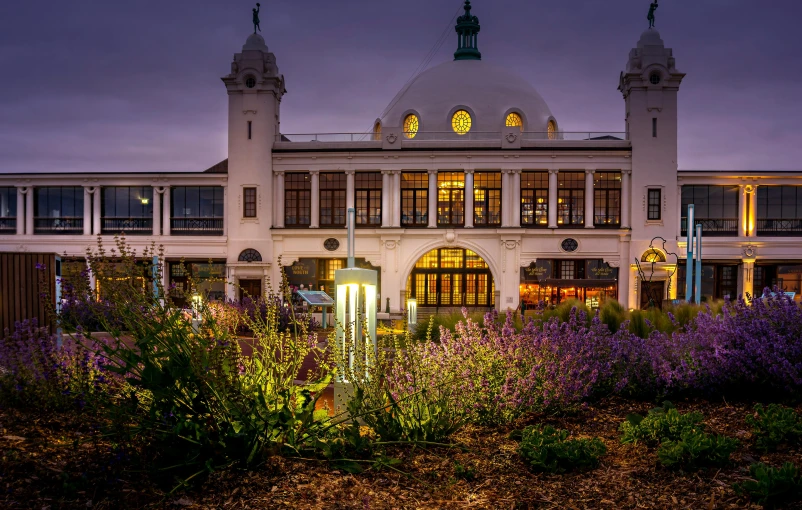 a large building with a dome on top of it, inspired by Edwin Deakin, unsplash contest winner, art nouveau, outdoor lighting, train station, parks and gardens, victorian harbour night