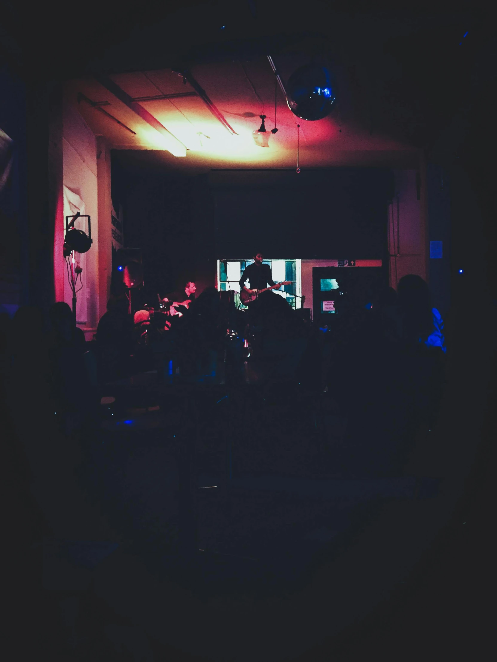 a group of people standing in a dark room, an album cover, unsplash, happening, live performance, low quality photo, full daylight, saturday night in a saloon