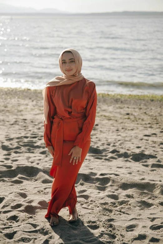 a woman in a red dress standing on a beach, inspired by Nazmi Ziya Güran, hurufiyya, wearing an orange jumpsuit, wearing business casual dress, square, high-quality photo