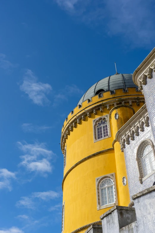 a yellow and white building with a blue sky in the background, inspired by Nadir Afonso, baroque, circular towers, the castle, portugal, dome