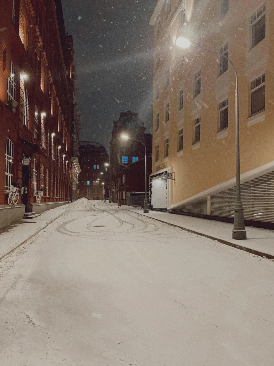 a street filled with lots of snow next to tall buildings, a picture, pexels contest winner, hyperrealism, ☁🌪🌙👩🏾, sovietwave aesthetic, narrow and winding cozy streets, harsh flash photo at night