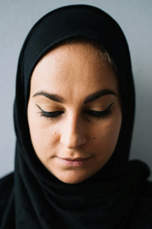 a close up of a person wearing a headscarf, winged eyelashes, ameera al taweel, slightly minimal, half - closed eyes