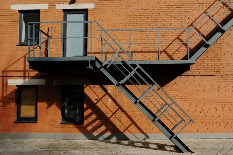 a metal staircase going up the side of a brick building, by Attila Meszlenyi, pexels contest winner, modernism, square, bartlomiej gawel, the photo shows a large, platforms