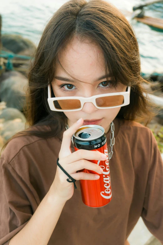 a woman holding a can of coke in front of her face, unsplash, photorealism, male ulzzang, digital sunglasses, bong, gongbi