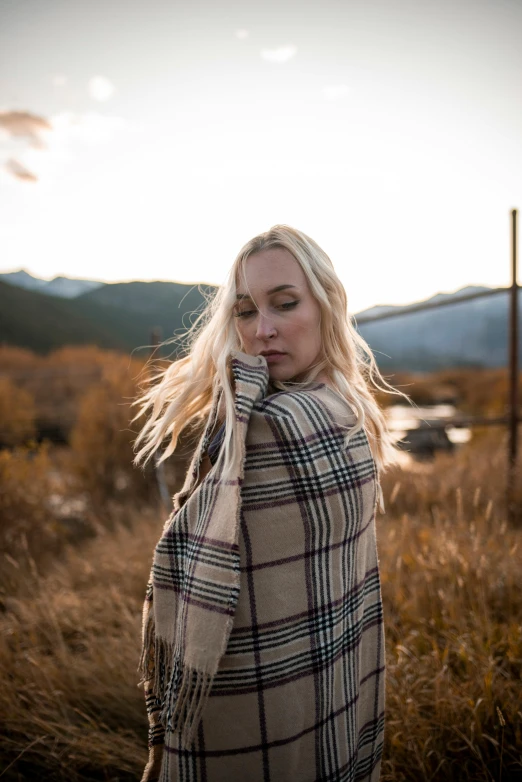 a woman wrapped in a blanket standing in a field, unsplash, avatar image, lumberjack flannel, blonde, instagram photo