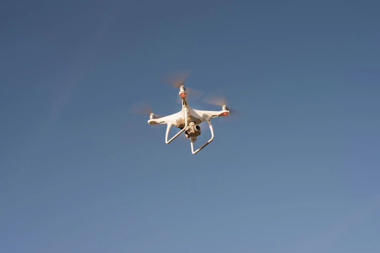 a white drone flying through a blue sky, figuration libre, uploaded, feature, vehicle, square