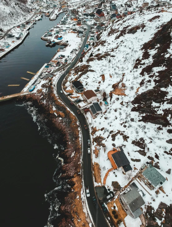 an aerial view of a road next to a body of water, by Kyle Lambert, pexels contest winner, snowy fjord, built on a steep hill, thumbnail, small port village