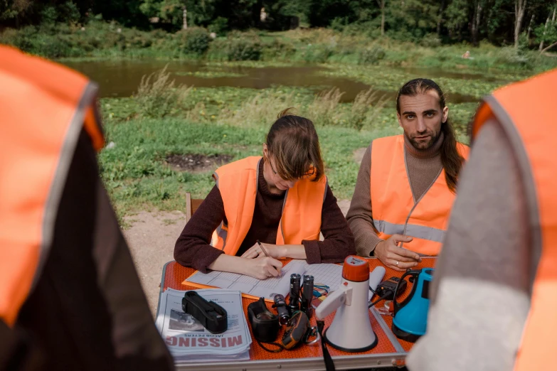 a group of people sitting around a table, technical vest, nature photo, worksafe. instagram photo, ewa juszkiewicz