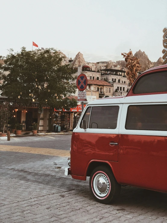 a red and white van parked on the side of a road, by Kristian Zahrtmann, pexels contest winner, old city, cave town, 7 0 s vibe, profile image