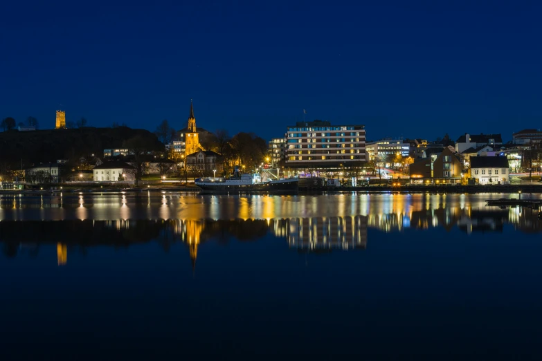 a large body of water next to a city at night, a picture, inspired by Wilhelm Marstrand, pexels contest winner, espoo, mirror and glass surfaces, spring evening, brown
