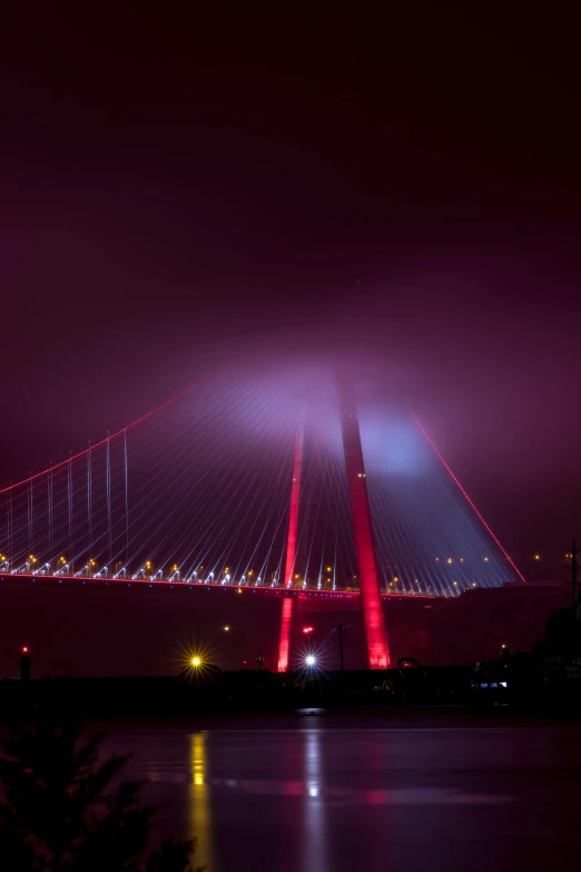 a bridge over a body of water at night, by Ibrahim Kodra, red illuminating fog, istanbul, tyndall rays, 2022 photograph