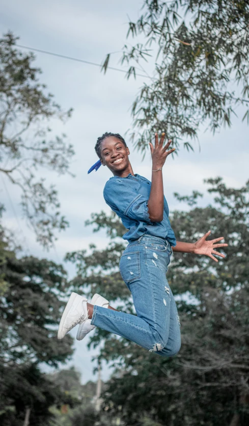 a person jumping in the air with a frisbee, by Lily Delissa Joseph, while smiling for a photograph, denim, avatar image, mongezi ncaphayi