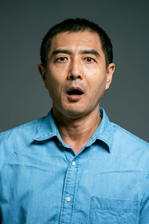 a man with a surprised look on his face, inspired by Zhang Xiaogang, pexels contest winner, shin hanga, wearing a light blue shirt, standup comedian, middle aged man, portrait of danny gonzalez