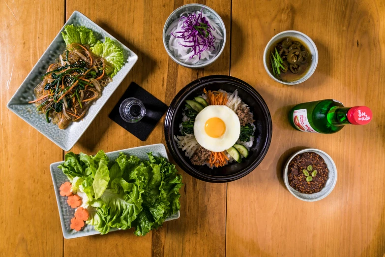 a wooden table topped with plates of food, a portrait, unsplash, mingei, korean, hasbulla, square, black