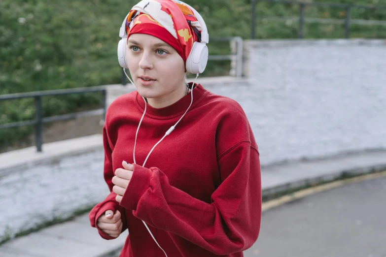 a woman wearing headphones and listening to music, inspired by Louisa Matthíasdóttir, happening, red sport clothing, muslim, taken in the early 2020s, 5k