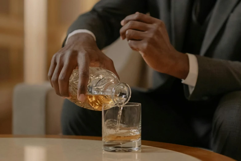 a man in a suit pouring whiskey into a glass, inspired by William Grant Stevenson, pexels contest winner, renaissance, black man, sitting in a lounge, crystal clear, slide show