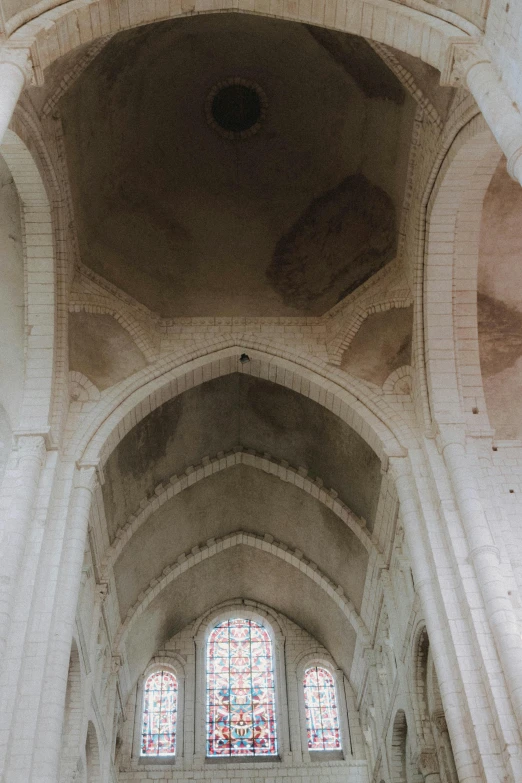 the inside of a church with a stained glass window, inspired by Barthélemy d'Eyck, unsplash, romanesque, very sparse detail, buttresses, panorama view, white