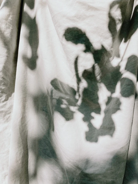 a black and white photo of a cat under a blanket, an abstract drawing, by Raoul Ubac, foliage clothing, shadow gradient, detail shots, printed on a cream linen t-shirt