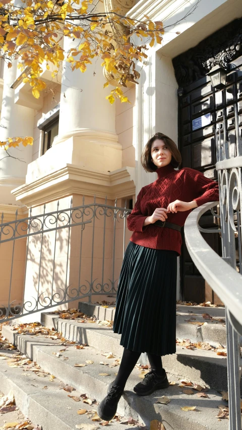 a woman standing on the steps of a building, instagram, wearing a red turtleneck sweater, pleated skirt, 15081959 21121991 01012000 4k, anna kovalevskaya