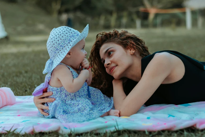 a woman laying on top of a blanket next to a baby, pexels contest winner, at the park, confident looking, 15081959 21121991 01012000 4k, thumbnail