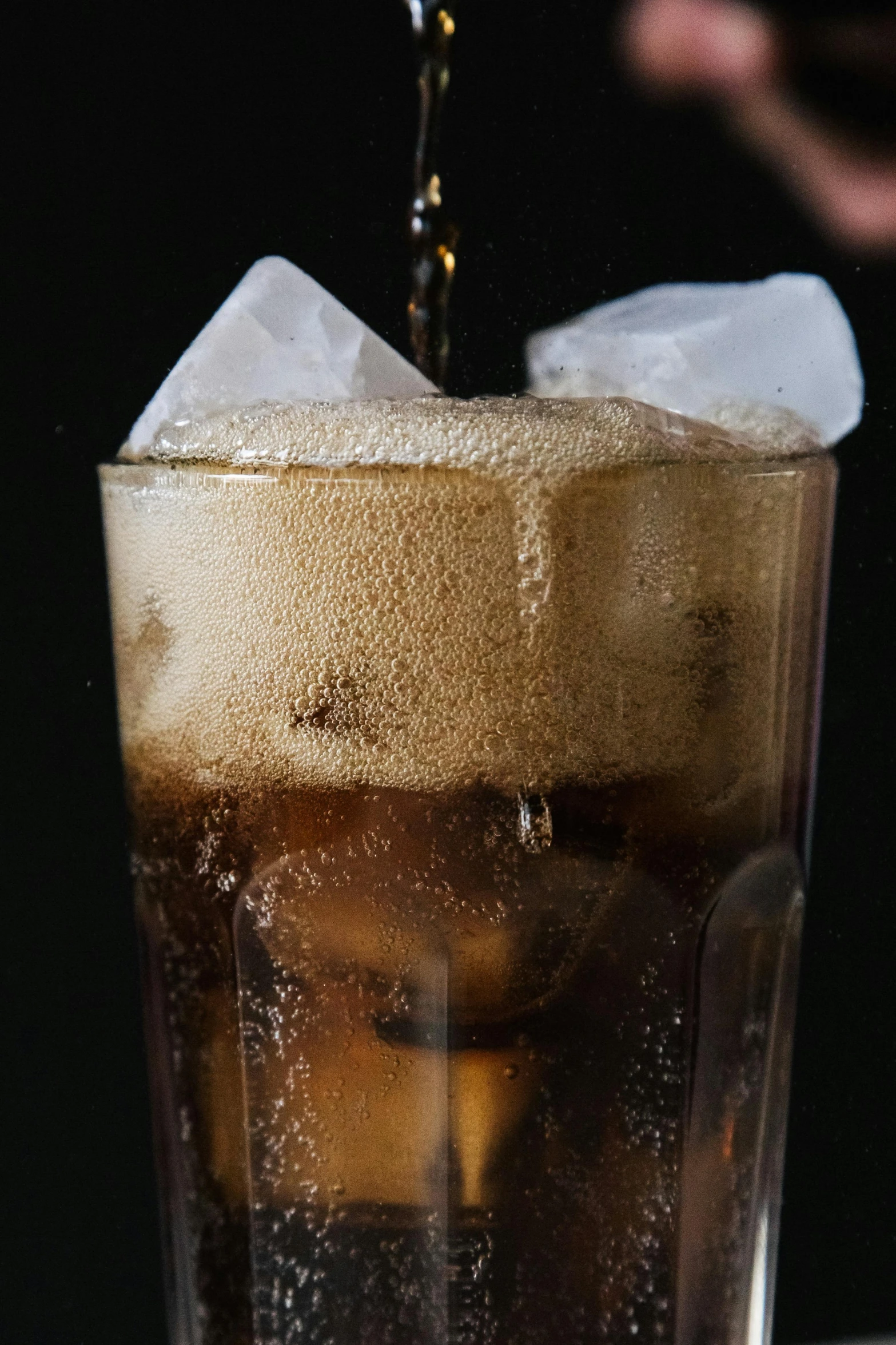 a close up of a drink being poured into a glass, a digital rendering, pexels, soda, black and brown, freezing, black