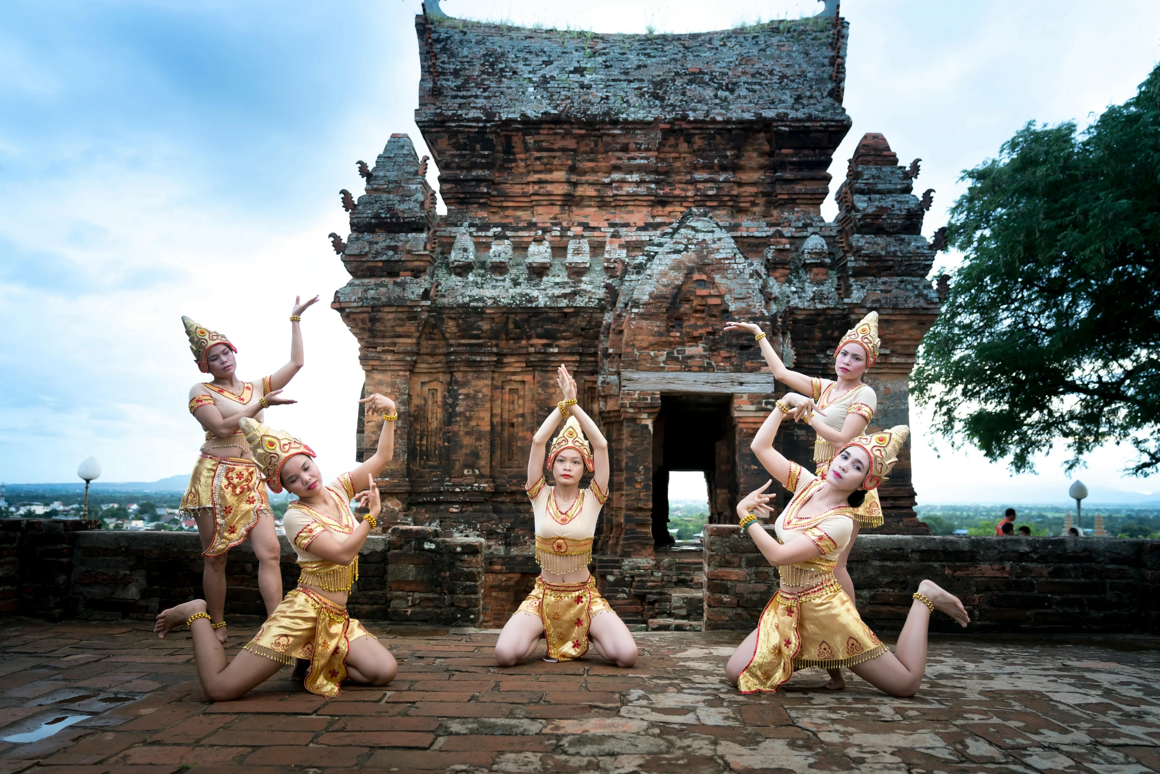 a group of dancers performing in front of a building, thai architecture, avatar image, high-resolution photo, square