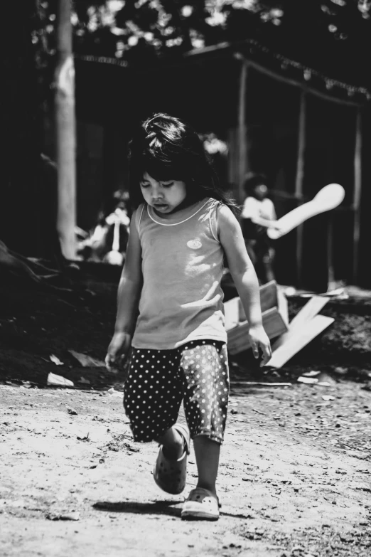 a little girl walking down a dirt road, a black and white photo, sumatraism, 8k 50mm iso 10, young!!!, after a battle, (beautiful) girl