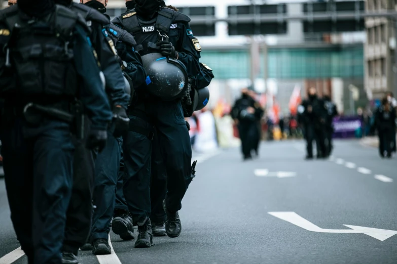 a group of police officers walking down a street, by Adam Marczyński, professional image, 🚿🗝📝