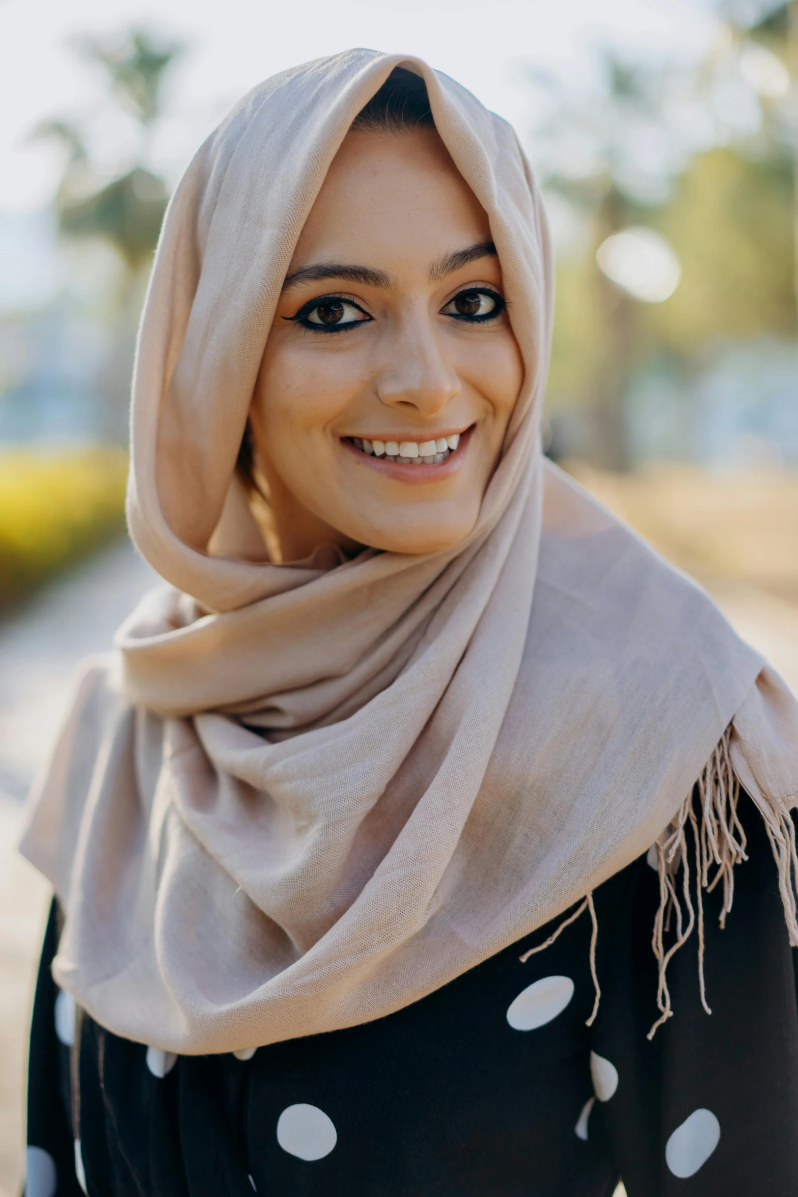 a close up of a person wearing a scarf, inspired by Maryam Hashemi, pexels contest winner, hurufiyya, elegant smiling pose, beige, islamic, student