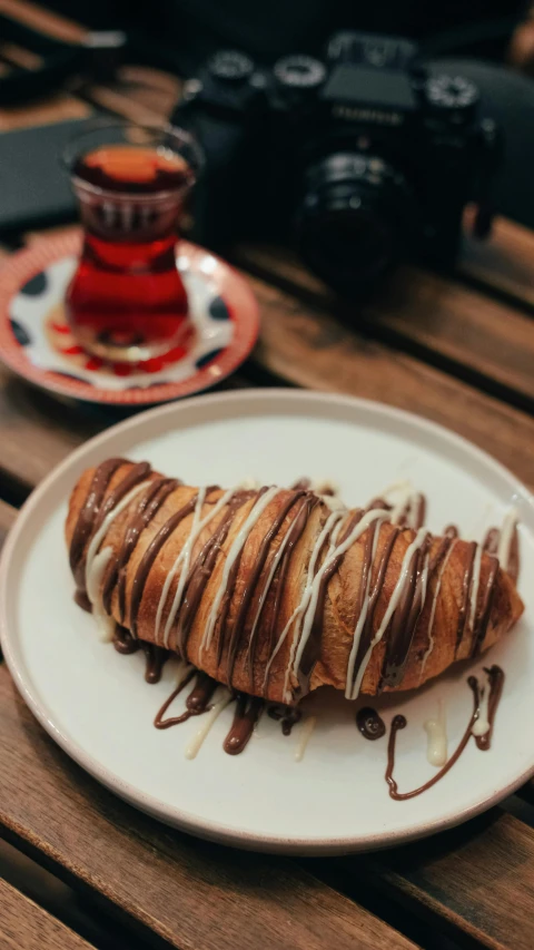 a close up of a plate of food on a table, by Basuki Abdullah, unsplash, hurufiyya, in the shape of a cinnamon roll, cone shaped, drink, fuji choco