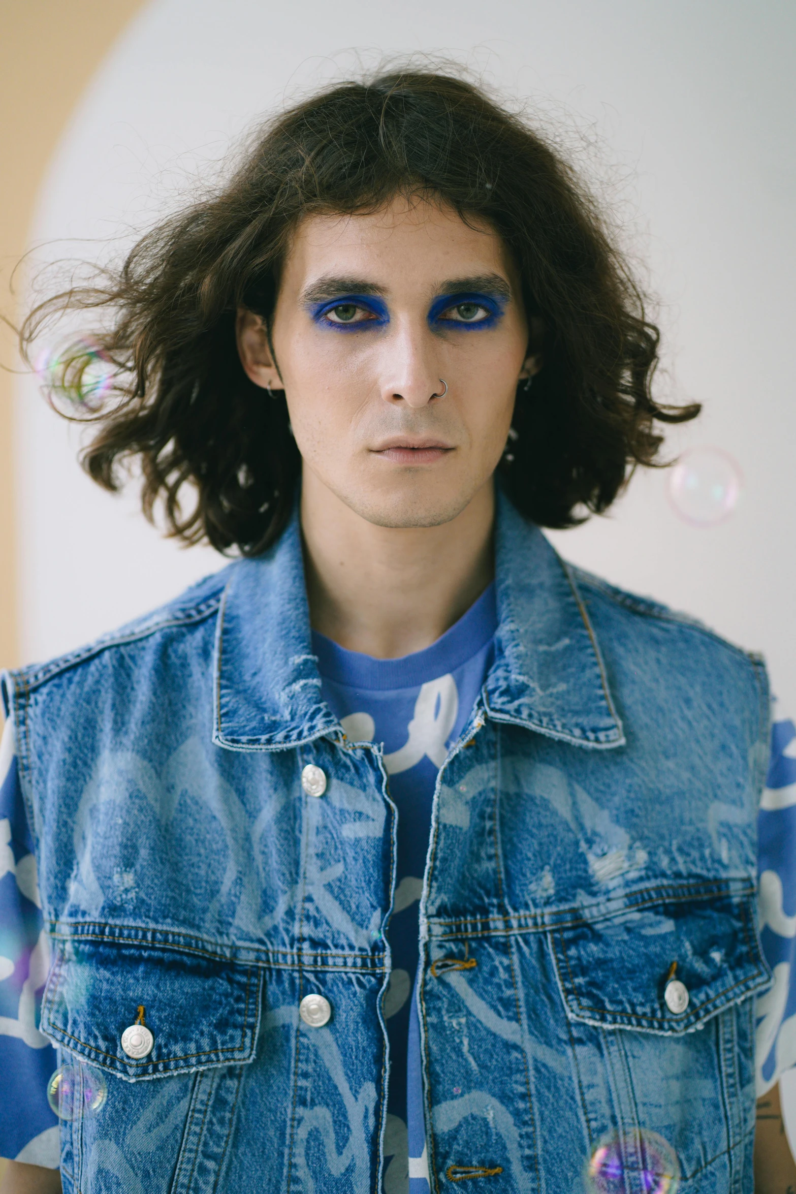 a man with long hair wearing a denim vest, an album cover, inspired by Davide Sasselli, drugstore, with blue skin, official store photo, joep hommerson