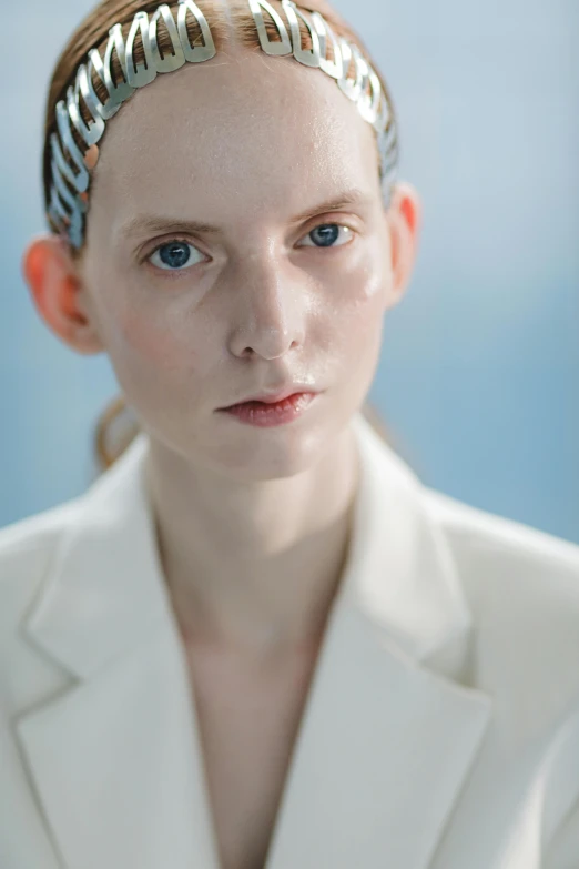 a woman in a white suit with a crown on her head, inspired by Vanessa Beecroft, unsplash, hyperrealism, blue eyes and large forehead, synthetic bio skin, thom browne, portrait of mia farrow