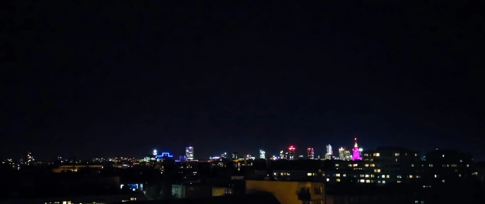 a view of a city at night from a rooftop, a picture, by Tom Wänerstrand, hurufiyya, panorama view of the sky, warsaw, high blue lights, night time footage