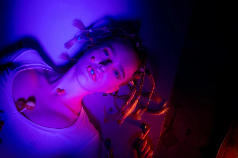 a woman laying on top of a bed under a purple light, inspired by Elsa Bleda, pexels contest winner, neon tube jewelry, julia garner, blue and red glowing lights, glowing mouth