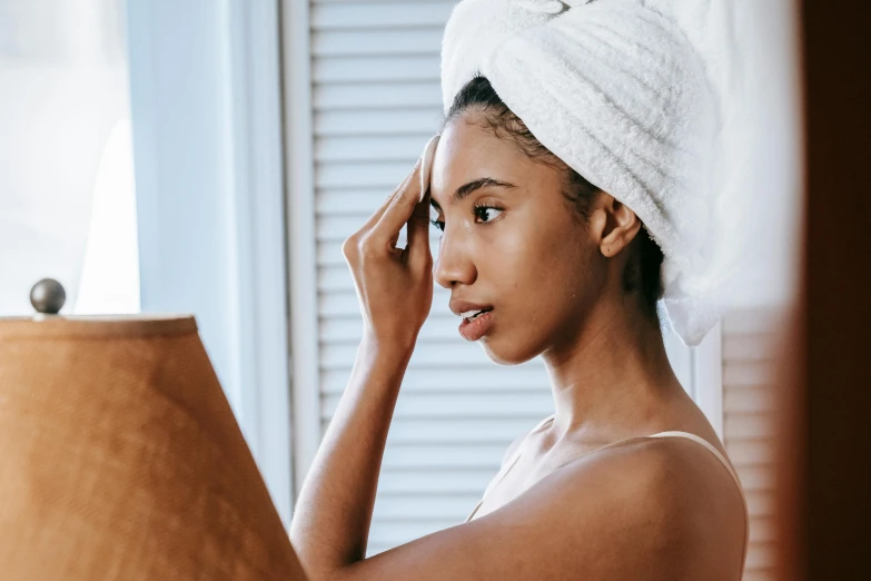 a woman with a towel on her head looking in a mirror, trending on pexels, renaissance, brown skinned, manuka, looking from side, professional image