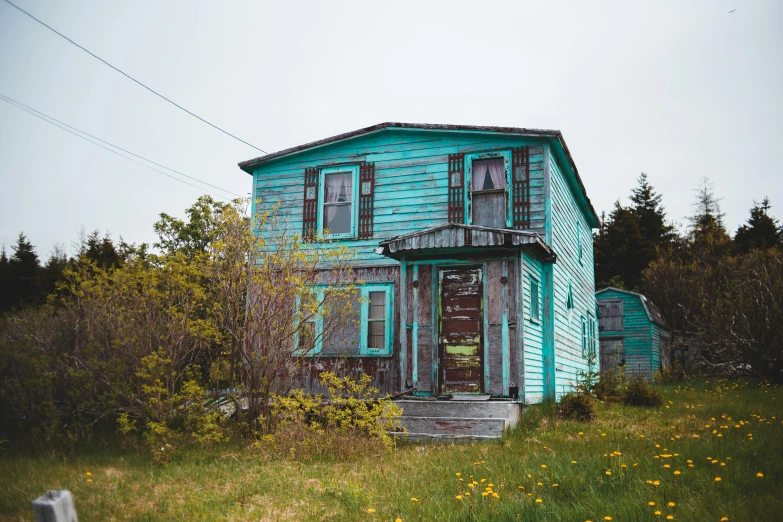 a blue house sitting in the middle of a field, a colorized photo, by Jessie Algie, pexels contest winner, turquoise rust, boarded up, moody : : wes anderson, a wooden