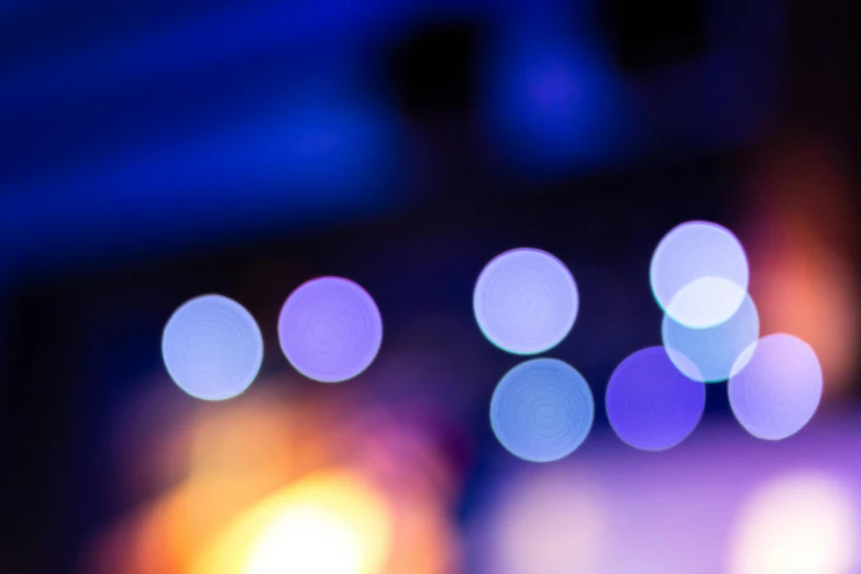 a blurry photo of some lights in a room, pexels, blue and purple, colorful dots, movie scene close up, blue and orange lighting