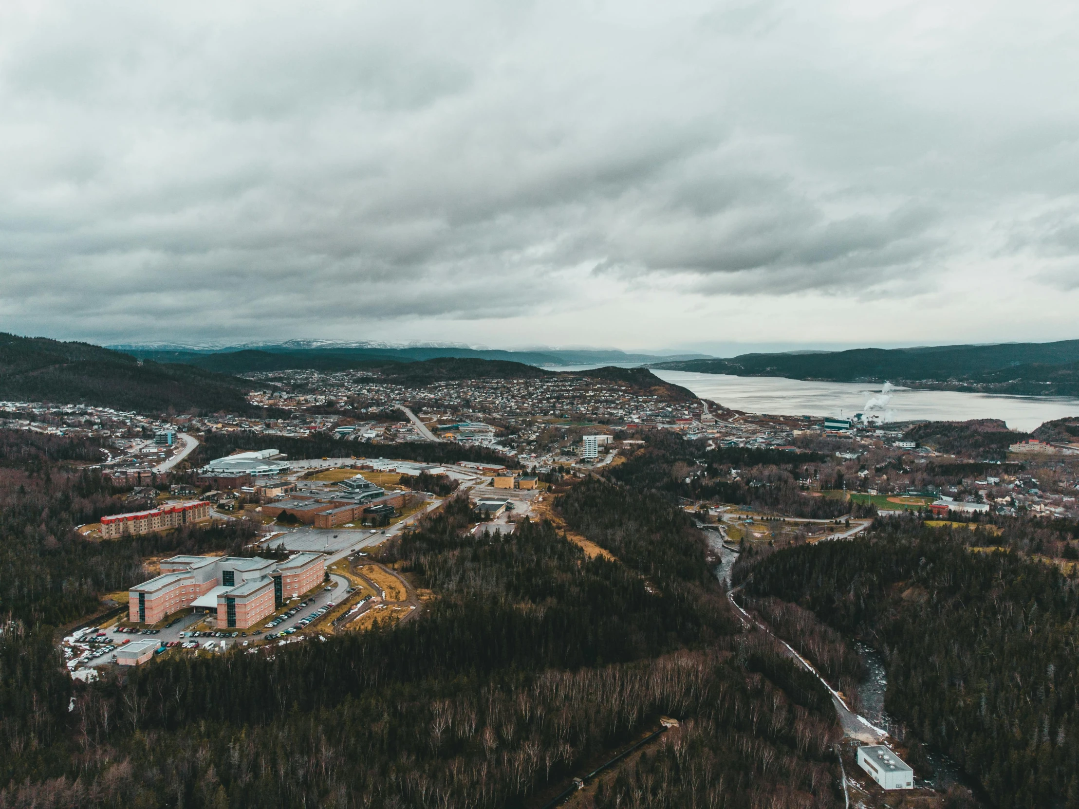 an aerial view of a town in the mountains, by Brian Snøddy, pexels contest winner, hurufiyya, grey cloudy skies, boreal forest, industrial surrounding, 2 0 0 0's photo