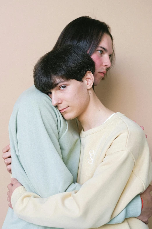two women hugging each other in front of a wall, an album cover, trending on pexels, delicate androgynous prince, portrait of depressed teen, two men hugging, 15081959 21121991 01012000 4k