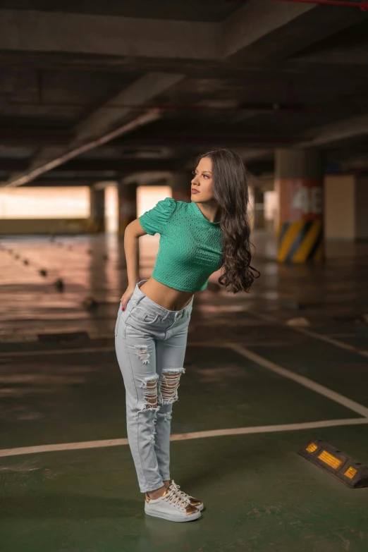 a beautiful young woman standing in a parking garage, by Mark Arian, pexels contest winner, ripped jeans, green shirt, avatar image, croptop