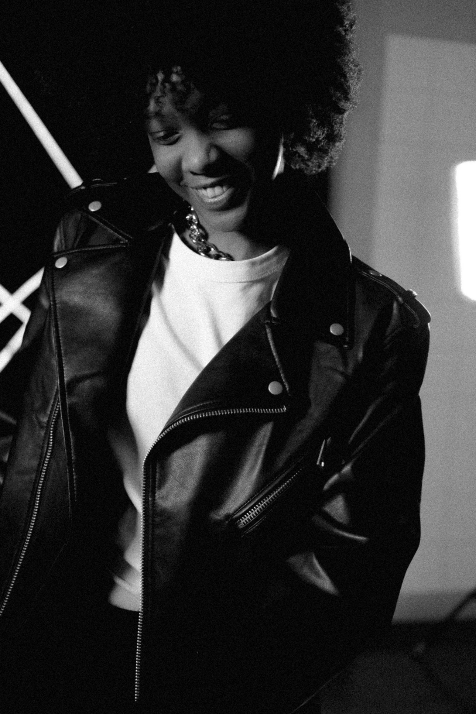 a black and white photo of a woman in a leather jacket, ashteroth, smiling sweetly, trending on imagestation, young prince