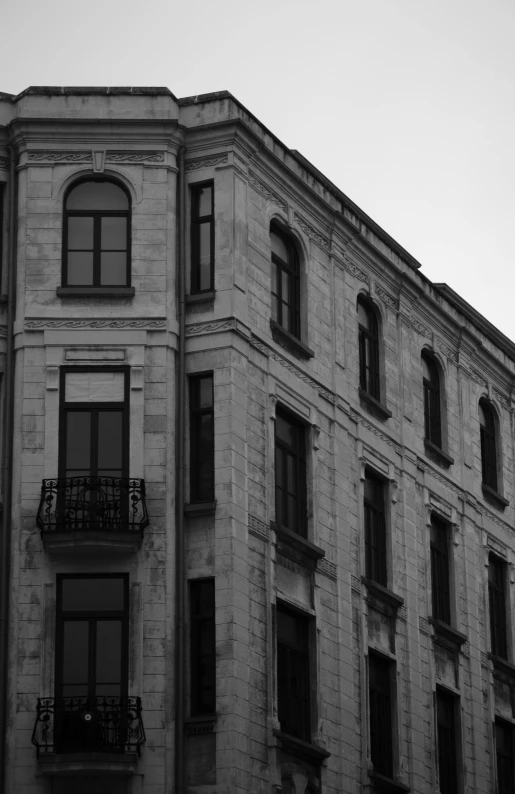 a black and white photo of a tall building, a black and white photo, by Tamas Galambos, pexels contest winner, neoclassicism, house windows, lviv, early evening, white marble buildings