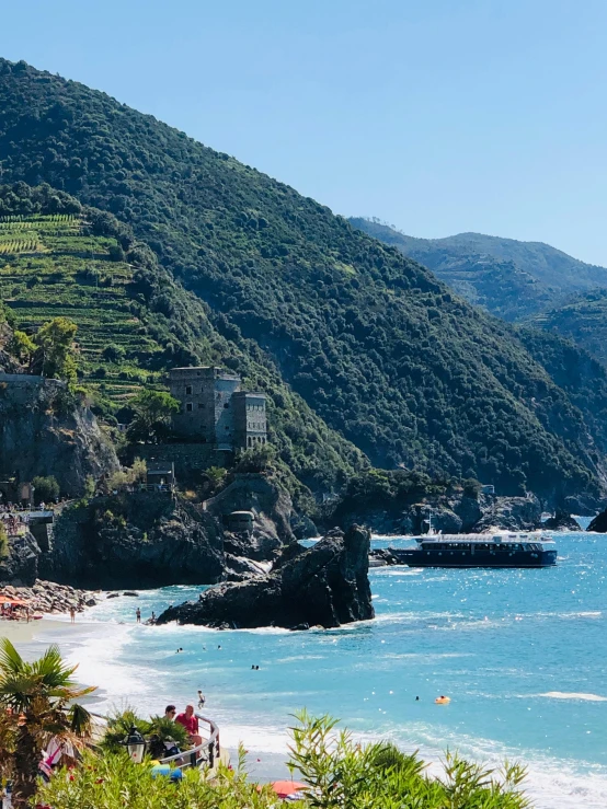 a group of people standing on top of a beach next to the ocean, cinq terre, lush surroundings, profile image