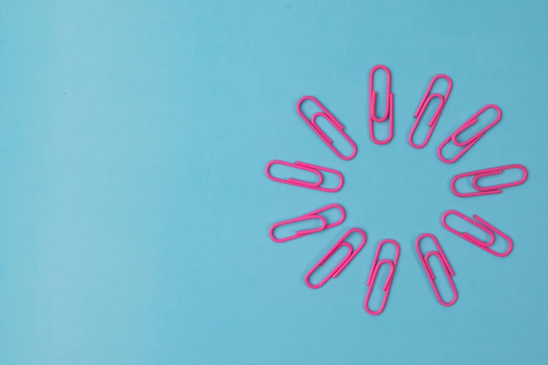pink paper clips arranged in a circle on a blue background, trending on pexels, pop art, wallpaperflare, healthcare, pink sun, press release