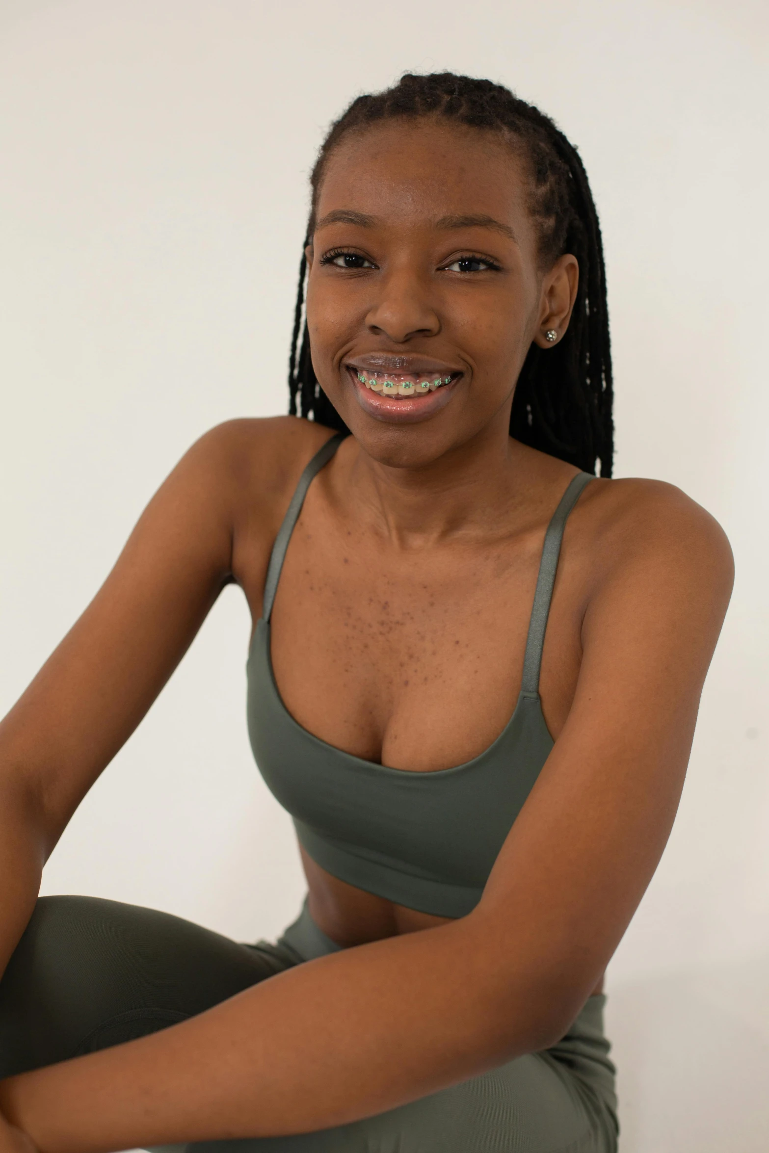 a woman in a sports bra top and leggings, by Gavin Hamilton, hurufiyya, with brown skin, smiling young woman, upper body image